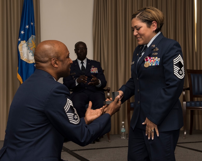Retired U.S. Air Force Chief Master Sgt. Robinson Joseph, left, former U.S. Air Forces in Europe – Air Forces Africa Chief Enlisted Manager for the Air Force Installation Contracting Center, proposes for the second time to his wife, retired Chief Master Sgt. Leenette Joseph, former USAFE Equal Opportunity functional manager, during their retirement ceremony on Ramstein Air Base, Germany, Oct. 25, 2019. Robinson said that he wanted to improve on his previous proposal, which was with an onion ring at a fast food restaurant.