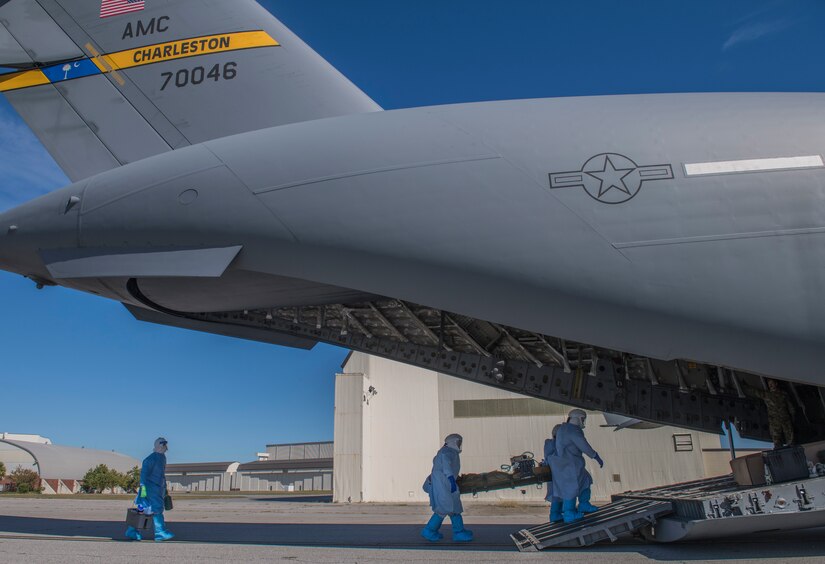 Members of the 43rd Aeromedical Evacuation Squadron from Pope Army Air Field, N.C., and 375th AES from Scott Air Force Base, Ill. carry a simulated Ebola patient onto a C-17 Globemaster III during a Transport Isolation System training exercise at Joint Base Charleston, S.C., October 23, 2019. The TIS is a device used to transport Ebola patients, either by C-17 Globemaster III or C-130 Hercules, while preventing the spread of disease to medical personnel and aircrews until the patient can get to one of three designated hospitals in the United States that can treat Ebola patients. JB Charleston is currently the only military installation with a TIS. The TIS mission is a sub-specialty of the aeromedical evacuation mission which requires frequent training to maintain readiness.