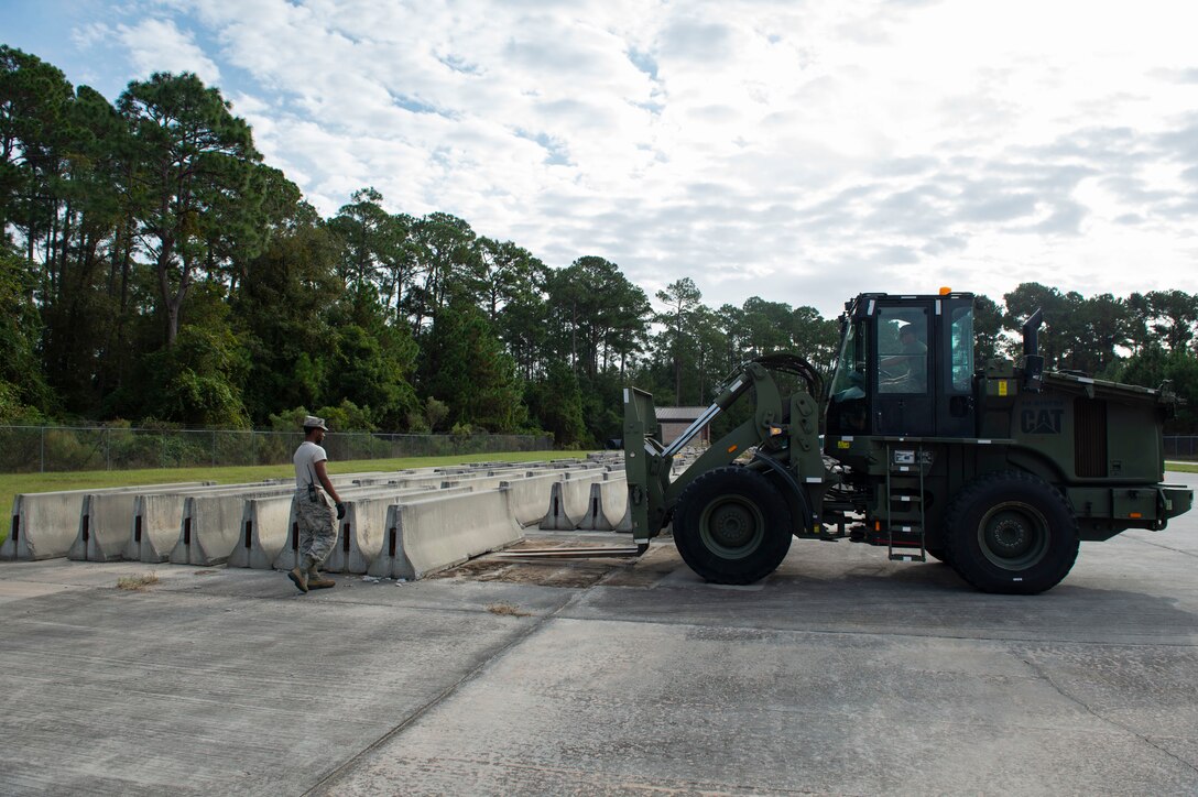 Airmen assigned to the 23d Logistics Readiness Squadron (LRS) prepare to move barriers Oct. 25, 2019, at Moody Air Force Base, Ga. The 23d LRS Airmen used cement barriers to close off the HC-130J Combat King II ramp for air show parking and to protect Moody’s assets and personnel. (U.S. Air Force photo by Airman Azaria E. Foster)