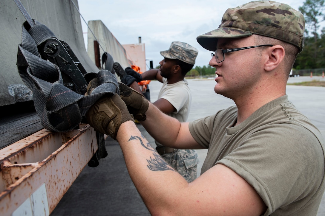 Senior Airman Maxwell Cisneros, 23d Logistics Readiness Squadron (LRS) ground transportation operator, secures cement barriers for transportation Oct. 25, 2019, at Moody Air Force Base, Ga. The 23d LRS Airmen used cement barriers to close off the HC-130J Combat King II ramp for air show parking and to protect Moody’s assets and personnel. (U.S. Air Force photo by Airman Azaria E. Foster)