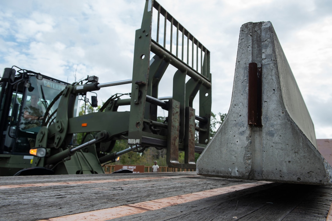 Airman 1st Class Lansing Jacquay, 23d Logistics Readiness Squadron (LRS) ground transportation operator, uses a fork lift to move a cement barrier Oct. 25, 2019, at Moody Air Force Base, Ga. The 23d LRS Airmen used cement barriers to close off the HC-130J Combat King II ramp for air show parking and to protect Moody’s assets and personnel. (U.S. Air Force photo by Airman Azaria E. Foster)