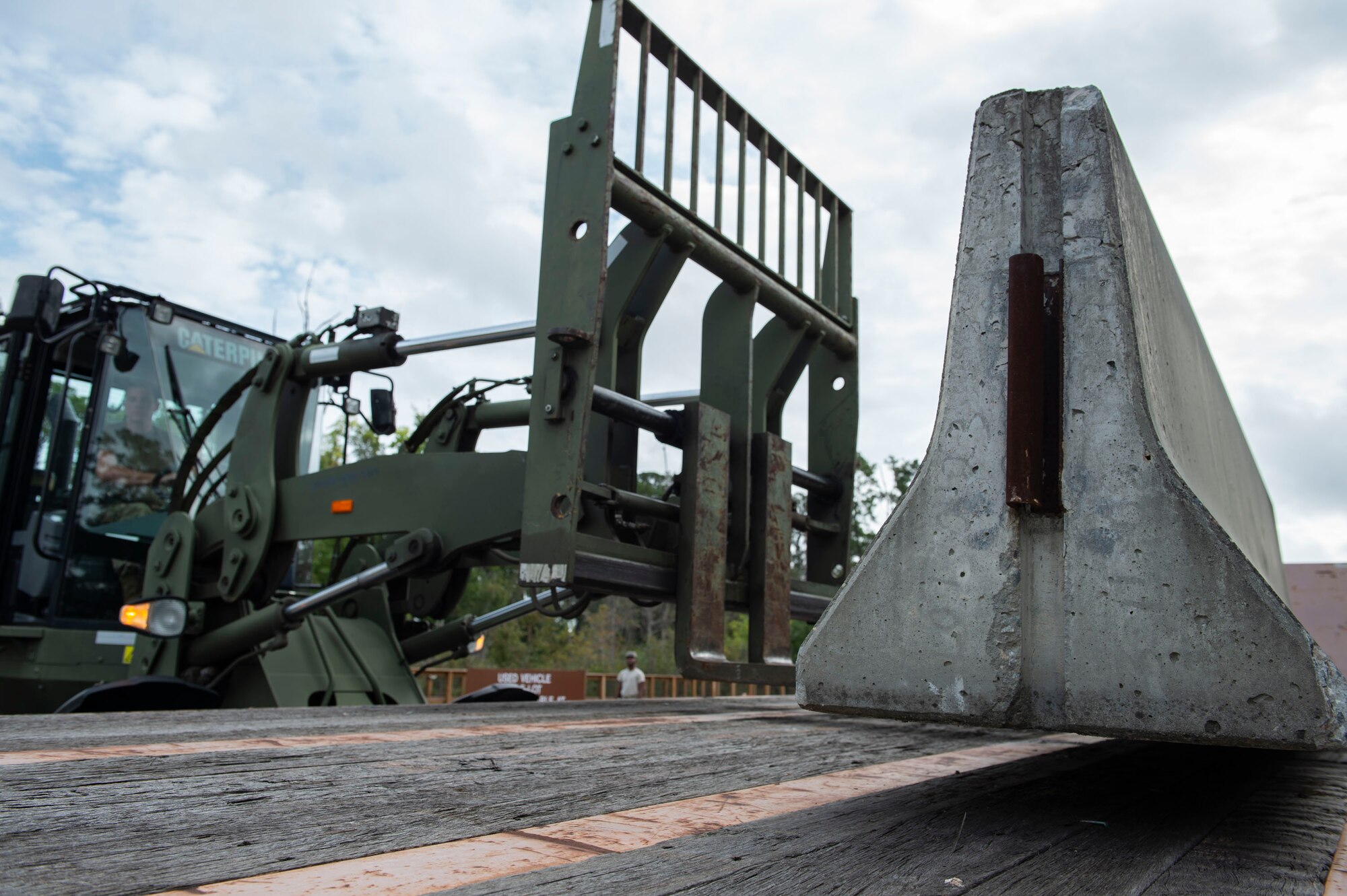 Airman 1st Class Lansing Jacquay, 23d Logistics Readiness Squadron (LRS) ground transportation operator, uses a fork lift to move a cement barrier Oct. 25, 2019, at Moody Air Force Base, Ga. The 23d LRS Airmen used cement barriers to close off the HC-130J Combat King II ramp for air show parking and to protect Moody’s assets and personnel. (U.S. Air Force photo by Airman Azaria E. Foster)