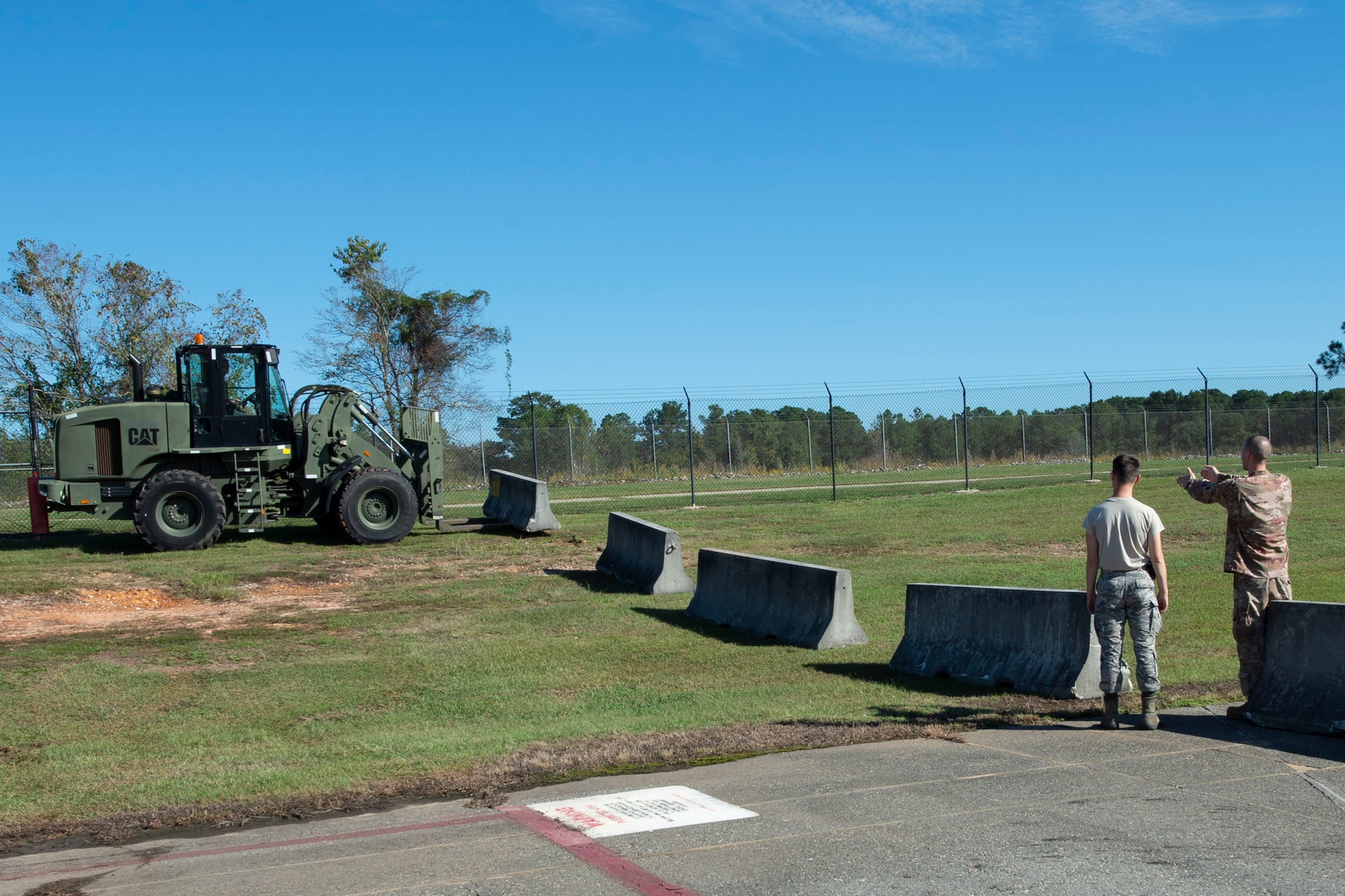 Airmen assigned to the 23d Logistics Readiness Squadron (LRS) place cement barriers on the flightline Oct. 28, 2019, at Moody Air Force Base, Ga. The 23d LRS Airmen used cement barriers to close off the HC-130J Combat King II ramp for air show parking and to protect Moody’s assets and personnel. (U.S. Air Force photo by Airman Azaria E. Foster)