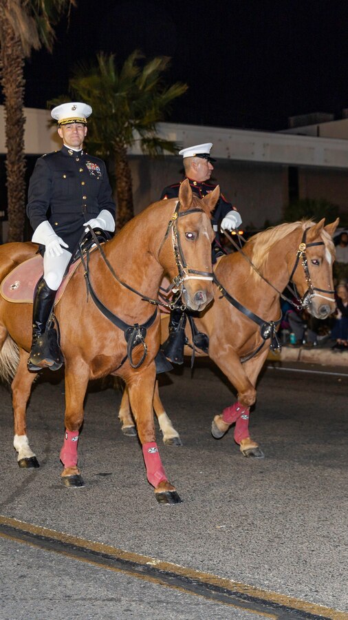 Colonel Craig C. Clemans (left), commanding officer of Marine Corps Logistics Base Barstow, and Sgt. Maj. Sergio MartinezRuiz, base sergeant major, ride in the Kiwanis Club's 87th annual Mardi Gras Parade in Barstow, Calif., Oct. 26. (U.S. Marine Corps photo by Jack J. Adamyk)