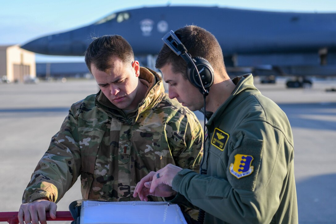 A member from the 28th Aircraft Maintenance Squadron and a crew member discuss preflight checks before launching B-1B Lancers from Ellsworth Air Force Base, S.D., Oct. 24, 2019. The deployment of this aircraft allows militaries from the United States and regional partner nations to train and work together to strengthen military-to-military relationships, promote regional security, improve combined tactical air operations and enhance interoperability of forces. The Department of Defense maintains command and control of its bomber force for any mission, anywhere in the world, at any time. (U.S. Air Force photo by Tech. Sgt. Jette Carr)