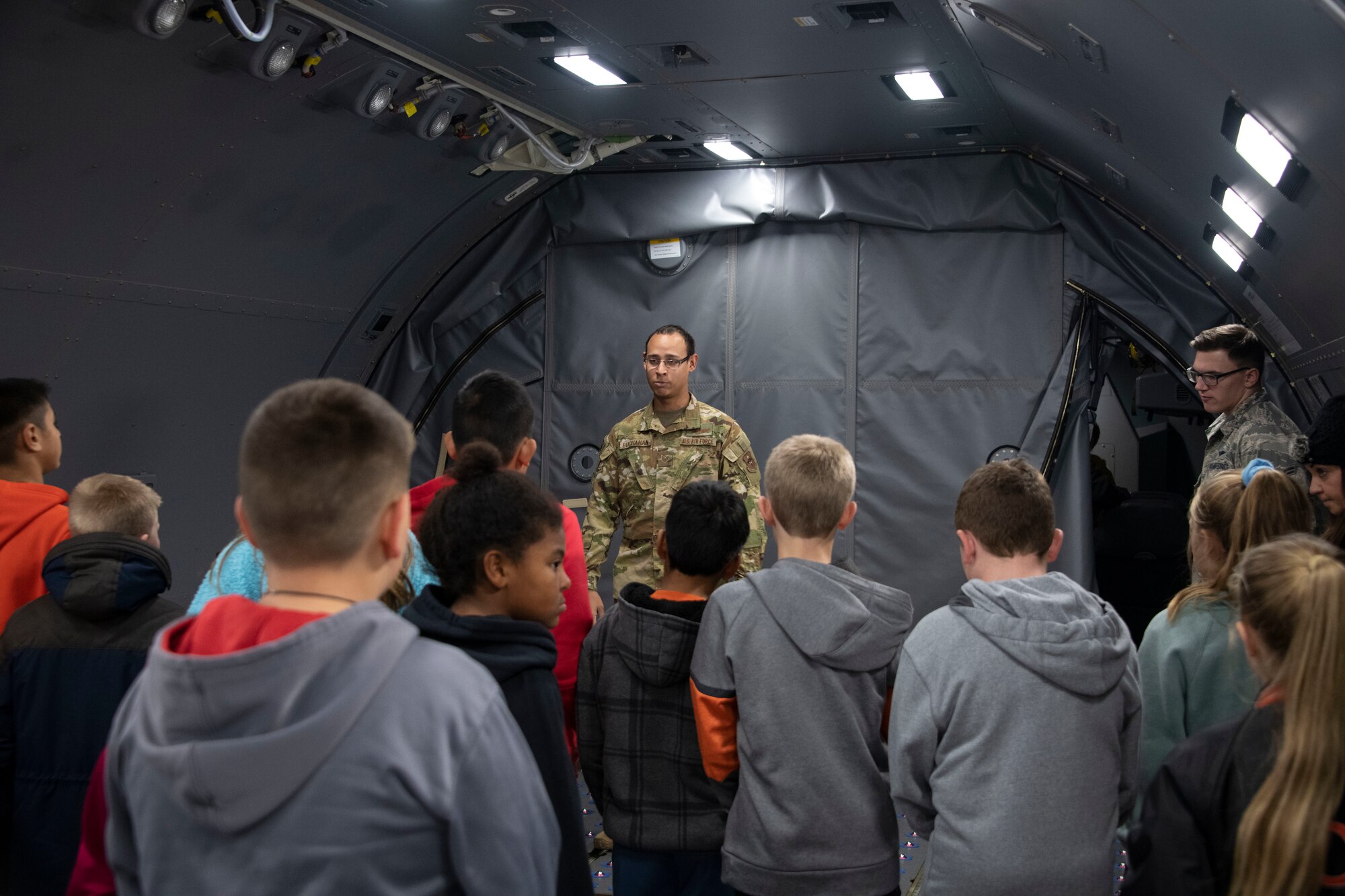 U.S. Air Force Staff Sgt. Michael Buchanan, a boom operator assigned to the 56th Air Refueling Squadron, explains the fuselage of the KC-46 Pegasus to students of the STARBASE program