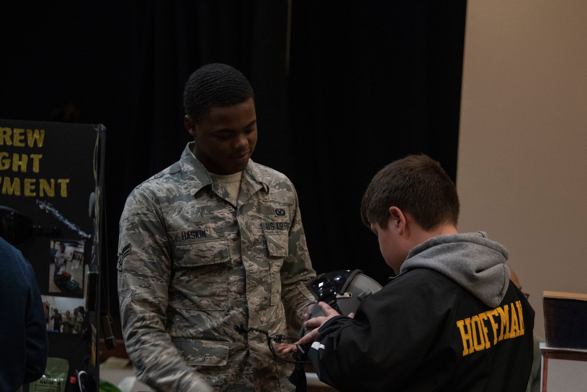 U.S. Air Force Airman 1st Class Eric Haskin, an aircrew flight equipment (AFE) apprentice assigned to 97th Operations Support Squadron, shows a helmet to a student of the STARBASE program