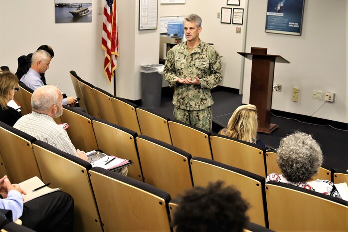 IMAGE: VIRGINIA BEACH, Va. (Oct. 22, 2019) – Capt. Scott Kraft, Naval Surface Warfare Center Indian Head Explosive Ordnance Disposal Technology Division commanding officer, briefs more than 30 safety and occupational health and environmental protection managers at the Naval Warfare Center’s two-day Safety and Environmental Face-to-Face Symposium. The managers shared innovative ideas, trends, and information impacting safety, occupational health, and environmental protection at the event hosted by Naval Surface Warfare Center Dahlgren Division Dam Neck Activity.  (U.S. Navy photo by George Bieber/Released)