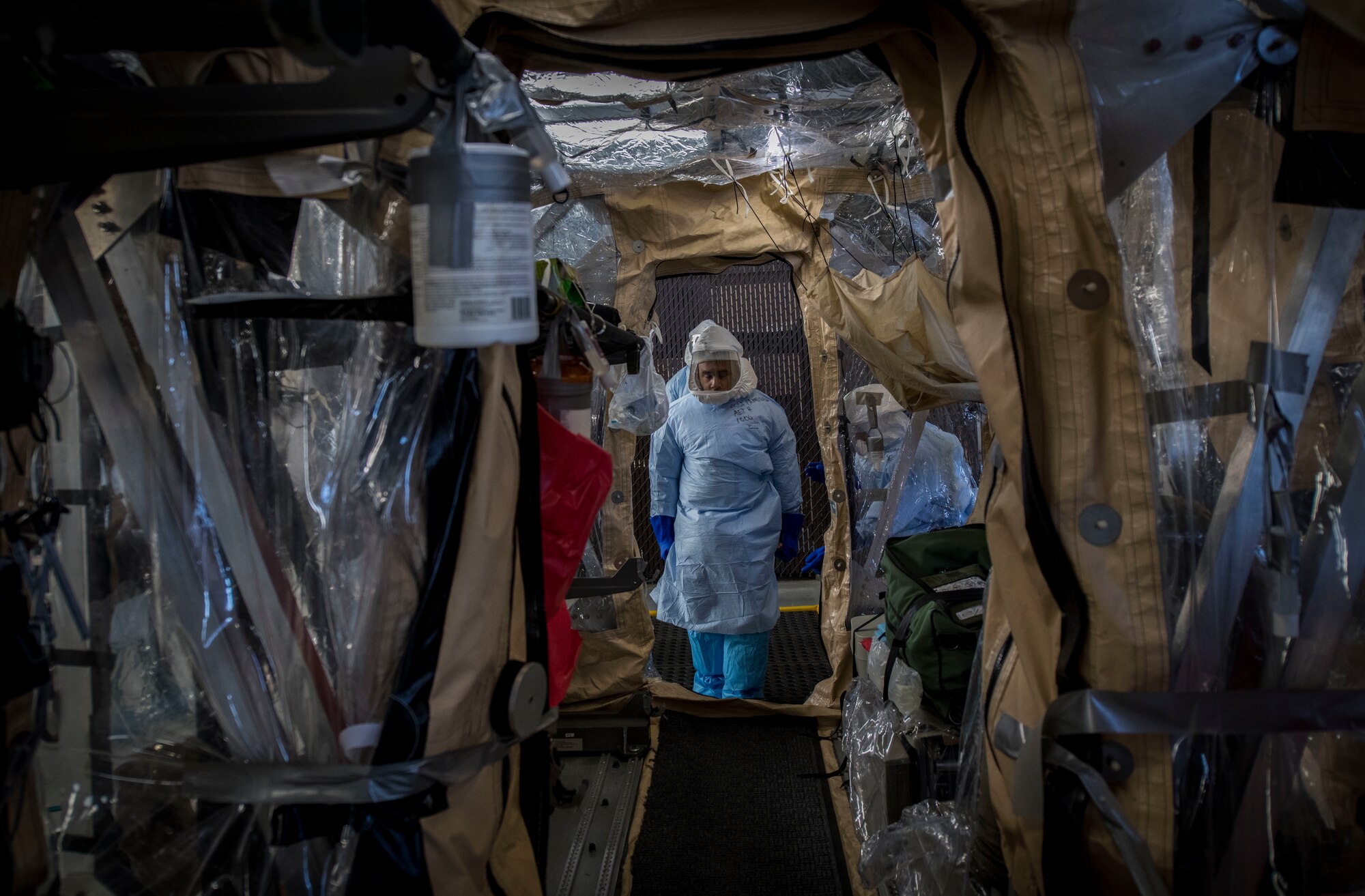 Staff Sgt. Clinton Campbell, an aeromedical evacuation technician assigned to the 375th Aeromedical Evacuation Squadron from Scott Air Force Base, Ill., carries a simulated Ebola patient on a litter into the Transport Isolation System during a Transport Isolation System training exercise at Joint Base Charleston, S.C., October 23, 2019. The TIS is a device used to transport Ebola patients, either by C-17 Globemaster III or C-130 Hercules, while preventing the spread of disease to medical personnel and aircrews until the patient can get to one of three designated hospitals in the United States that can treat Ebola patients. JB Charleston is currently the only military installation with a TIS. The TIS mission is a sub-specialty of the aeromedical evacuation mission which requires frequent training to maintain readiness.