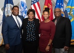 Family of four poses in front of flags