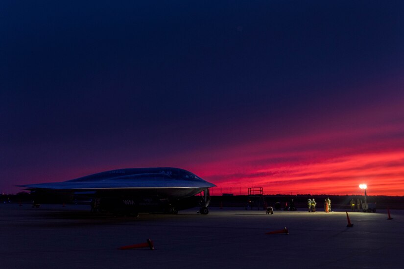 A plane sits parked at night.