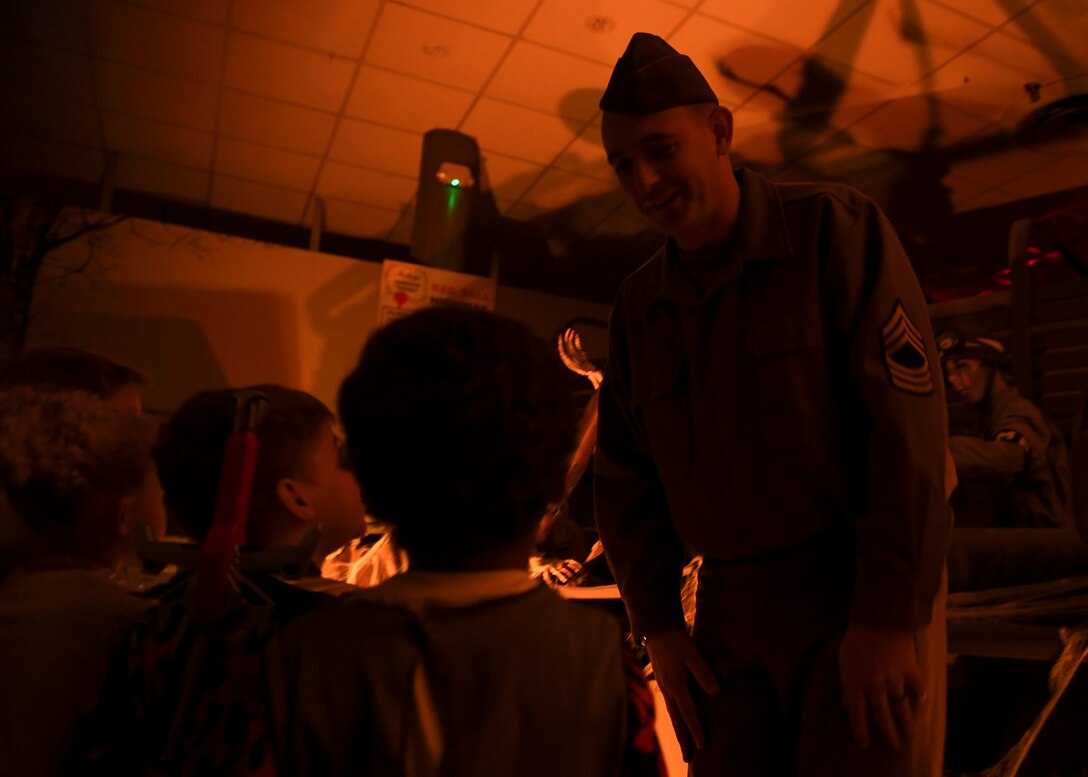 A U.S. Army Transportation volunteer talks to children attending the Night at the Transportation Museum Halloween celebration at Joint Base Langley-Eustis, Virginia, Oct. 28, 2019.