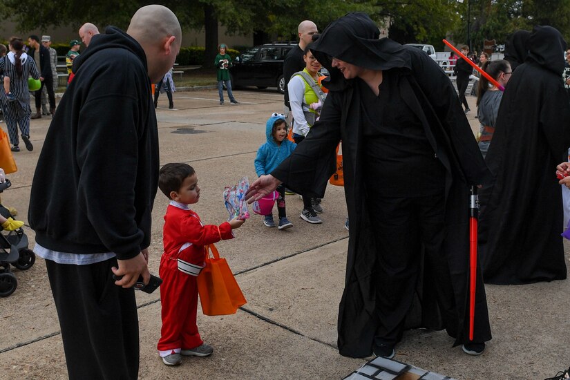 A participant at the Fort Eustis Fall Fest hands gifts to a child at Joint Base Langley-Eustis, Virginia, Oct. 25, 2019.