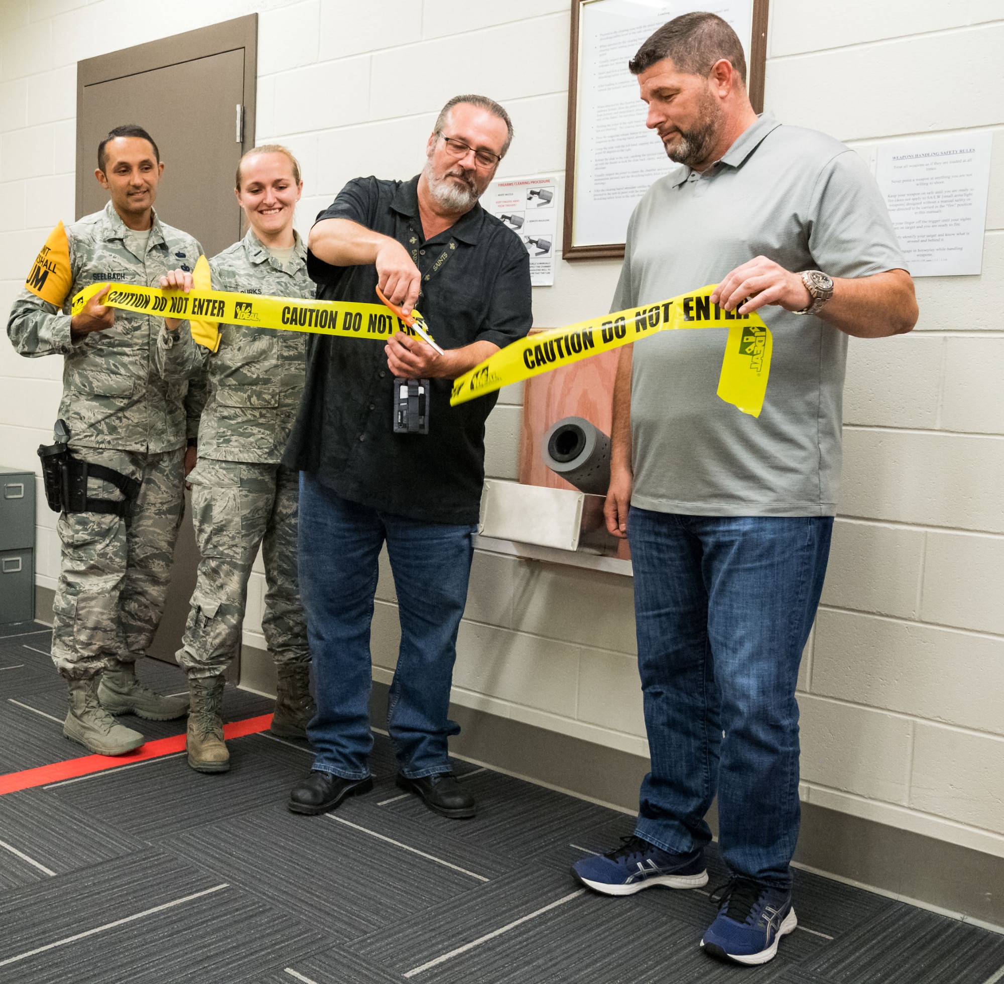 Tech. Sgt. Damien Seelbach, 436th Communications Squadron cybersecurity noncommissioned officer in charge and Unit Marshal; 1st Lt. Rachael Burks, 436 CS cyber operations flight commander and Unit Marshal; Dr. Craig Gilbert, 436 CS chief of knowledge management and Unit Marshal Program Manager; and Richard Barker, 436th Security Forces Squadron, participate in a ribbon-cutting ceremony in the 436 CS’s arming area, Oct. 24, 2019, on Dover Air Force Base, Del. The 436 CS is the first squadron in the Air Force to create its own arming area in support of the Unit Marshal Program. (U.S. Air Force photo by Roland Balik)