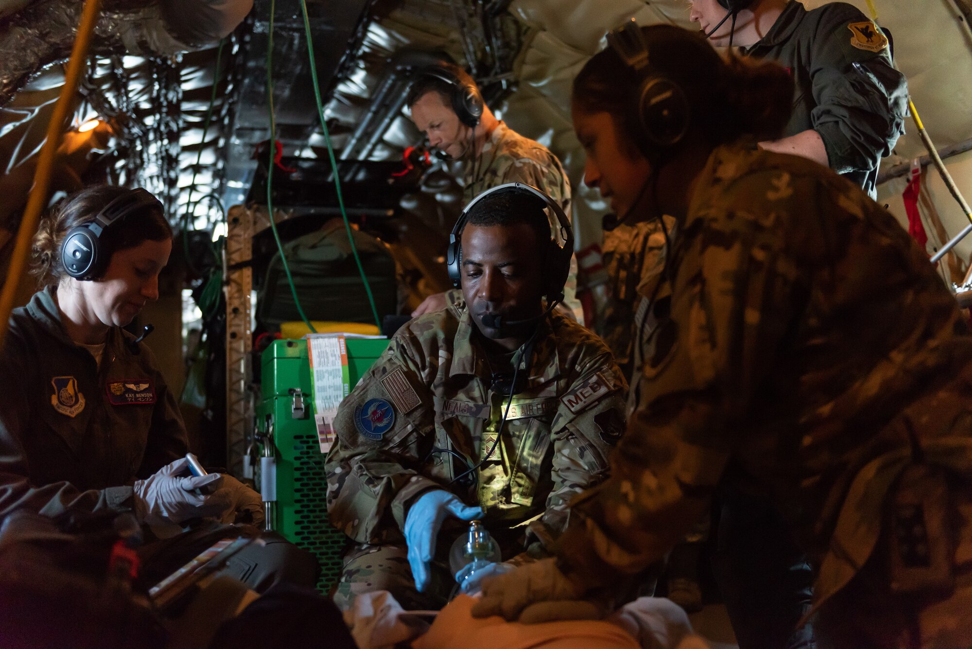 Airmen from the 18th Aeromedical Evacuation Squadron simulate life-saving procedures to a training mannequin onboard a KC-135 Stratotanker during an exercise at Kadena Air Base, Japan, Oct. 8, 2019. The 18th AES deploys and operates elements of a theater aeromedical evacuation system capable of worldwide taskings. (U.S. Air Force photo by Senior Airman Matthew Seefeldt)