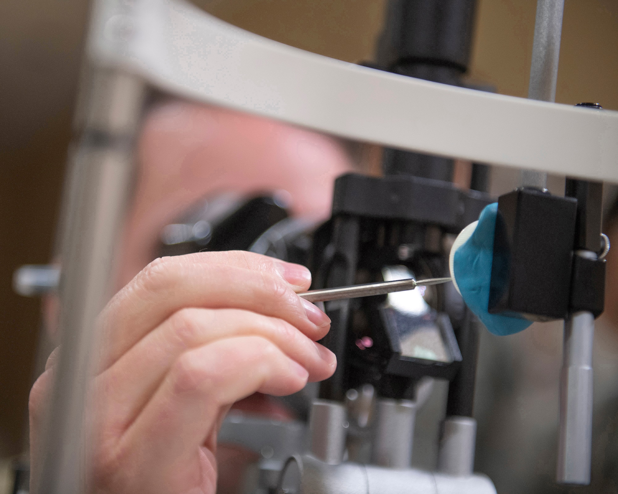 U.S. Air Force Col. Jeffrey Nelson, 60th Air Mobility Wing commander, takes foreign bodies off a simulated eyeball during a visit to the optometry clinic during a Leadership Rounds visit at Travis Air Force Base, California, Oct. 18, 2019. The Leadership Rounds program provides 60th AMW leadership with an opportunity to interact with Airmen to get a detailed view of each mission performed at Travis AFB. (U.S. Air Force photo by Louis Briscese)