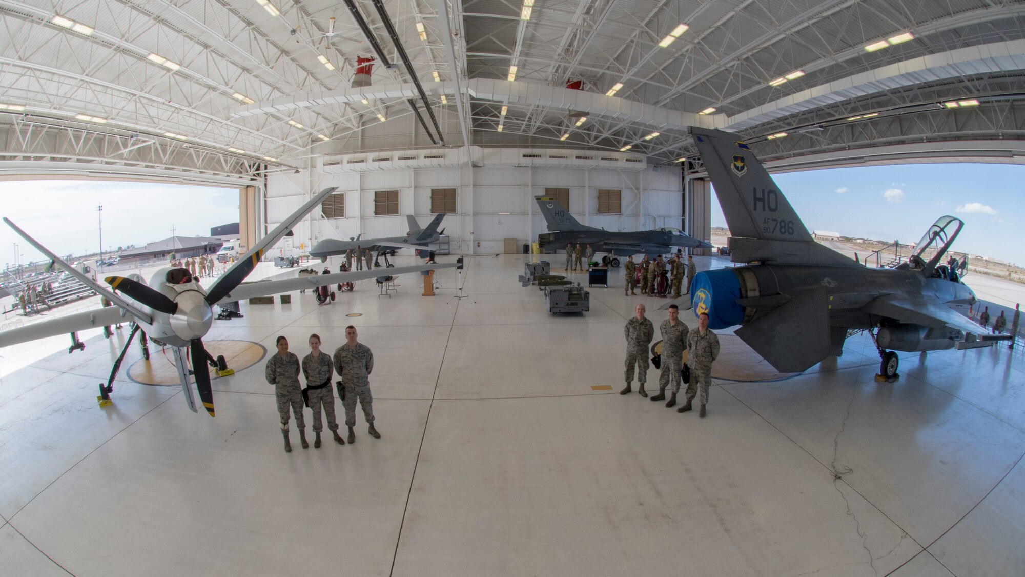 Airmen from the 49th Maintenance Group pose for a photo before the beginning of a load competition, Oct. 28, 2019, on Holloman Air Force Base, N.M. Two F-16 Vipers and two MQ-9 Reapers were used to test the loading skills of 12 Airmen during the 2019 third quarter load competition. (U.S. Air Force photo by Airman 1st Class Autumn Vogt)