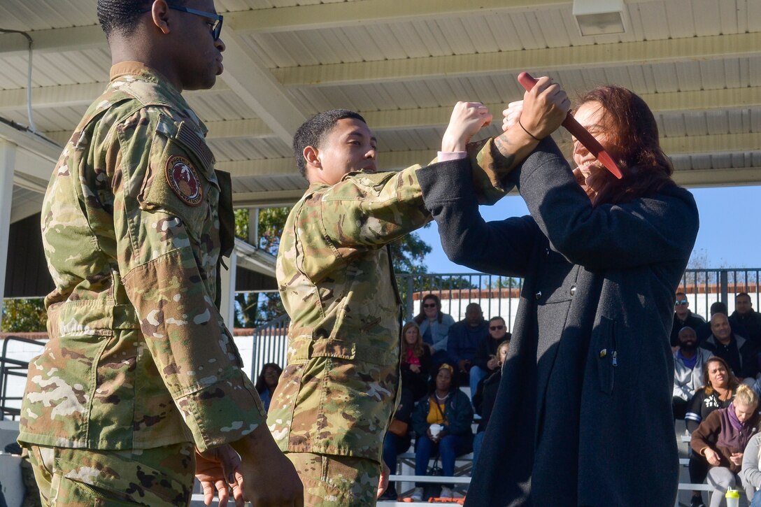 Elena Khovanskaya, DLA Troop Support Industrial Hardware purchasing agent (right), uses demonstrated techniques to remove a dummy knife from Air Force Staff Sgt. Jacob Sanchez, 87th Security Forces Phoenix Raven, as Staff Sgt. E-Quantay Mason, 87th SFS Phoenix Raven, looks on during an exhibition Oct. 23 at Joint Base McGuire-Dix-Lakehurst, N. J. The exhibition was part of a DLA Troop Support Academy joint base tour showcasing some of Troop Support’s Warfighter customers.