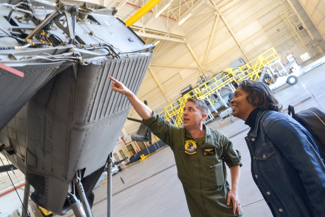 Marine Maj. Mitchell Kustener, 49 Marine Aircraft Group pilot, shows Linda Crawford, DLA Troop Support Industrial Hardware contract specialist, an o-ring on the back of a CH-53E Super Stallion during a tour of Joint Base McGuire-Dix-Lakehurst, N.J. Oct 23. Crawford procures o-rings and other repair parts for Troop Support’s Warfighter customers. (Photo by Christian DeLuca)