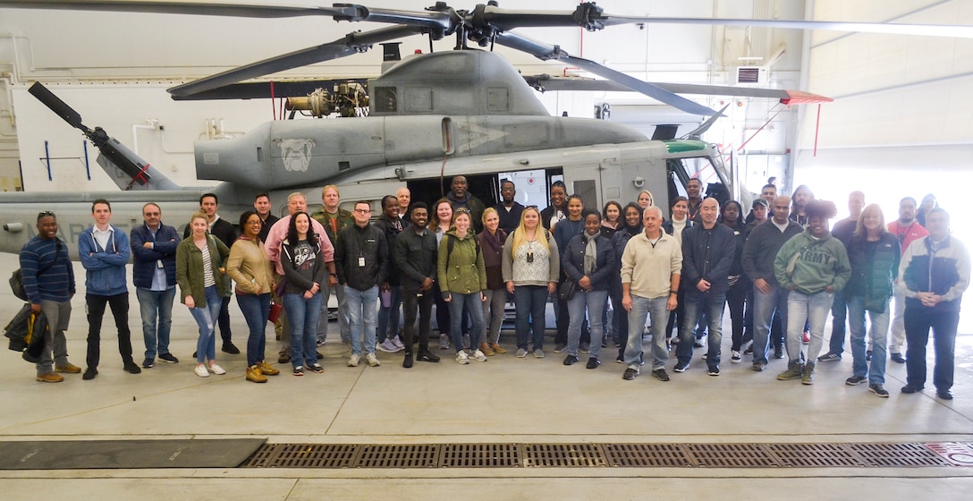 DLA Troop Support employees pose in front of a UH-1Y Venom during a tour of Joint Base McGuire-Dix-Lakehurst, N.J., Oct 23. The tour was part of the DLA Troop Support Academy, a three-day course designed to give new employees a broader understanding of the organization and its customers. (Photo by Christian DeLuca)