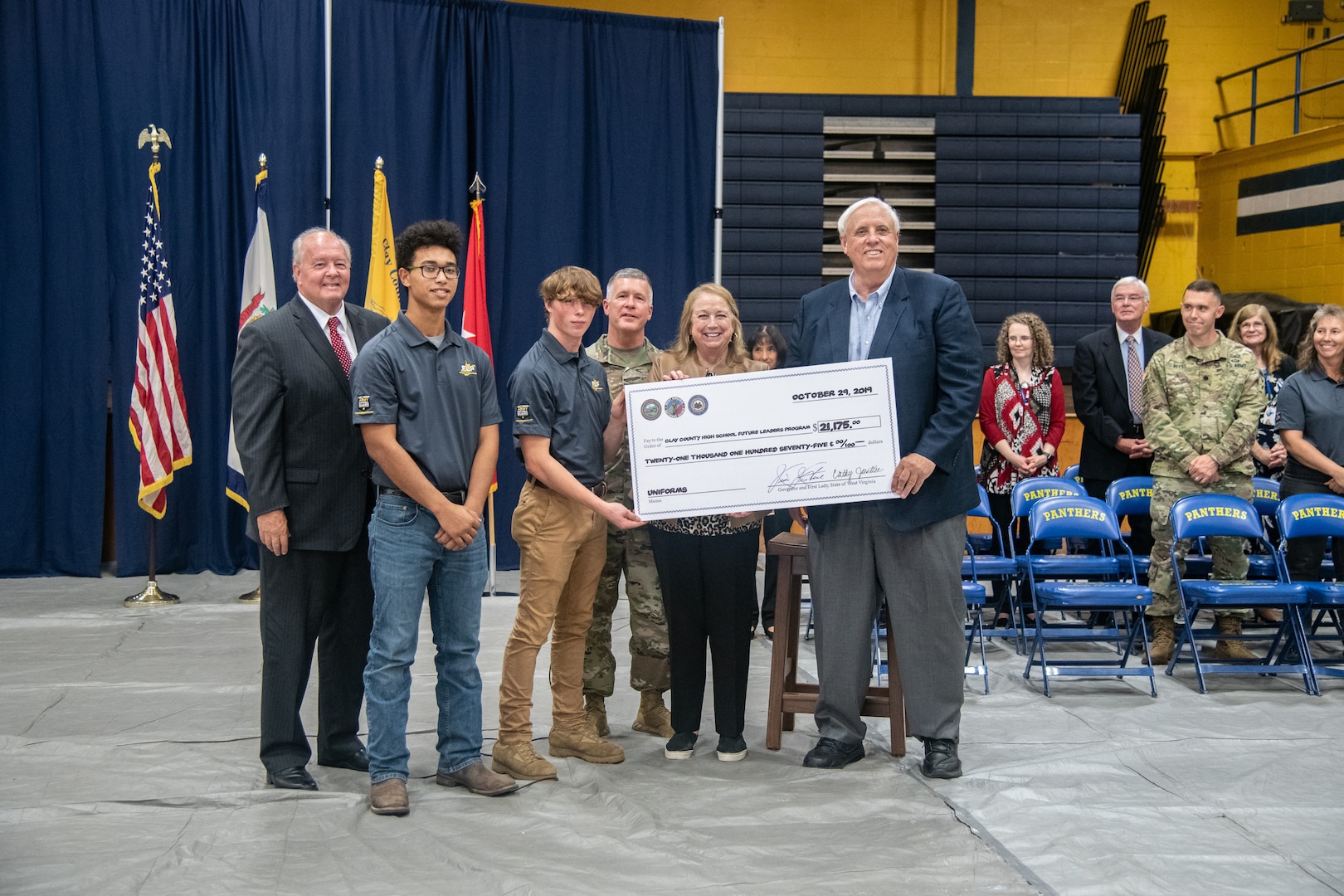 West Virginia Gov. Jim Justice and First Lady Cathy Justice, Maj. Gen. James Hoyer, West Virginia Adjutant General, and West Virginia State Superintendent Dr. Steven L. Paine present a ceremonial check to two West Virginia National Guard (WVNG) Future Leaders Program (FLP) students that will be used to help fund their program after a ceremony at Clay County High School Oct. 29, 2019. The WVNG FLP is designed to assist high schools in providing military and leadership-based curriculum, mentorship, and guidance to high school students that aid in character and leadership development, tailored to the needs and requests of participating schools in West Virginia. (U.S. Army National Guard photo by Edwin L. Wriston)