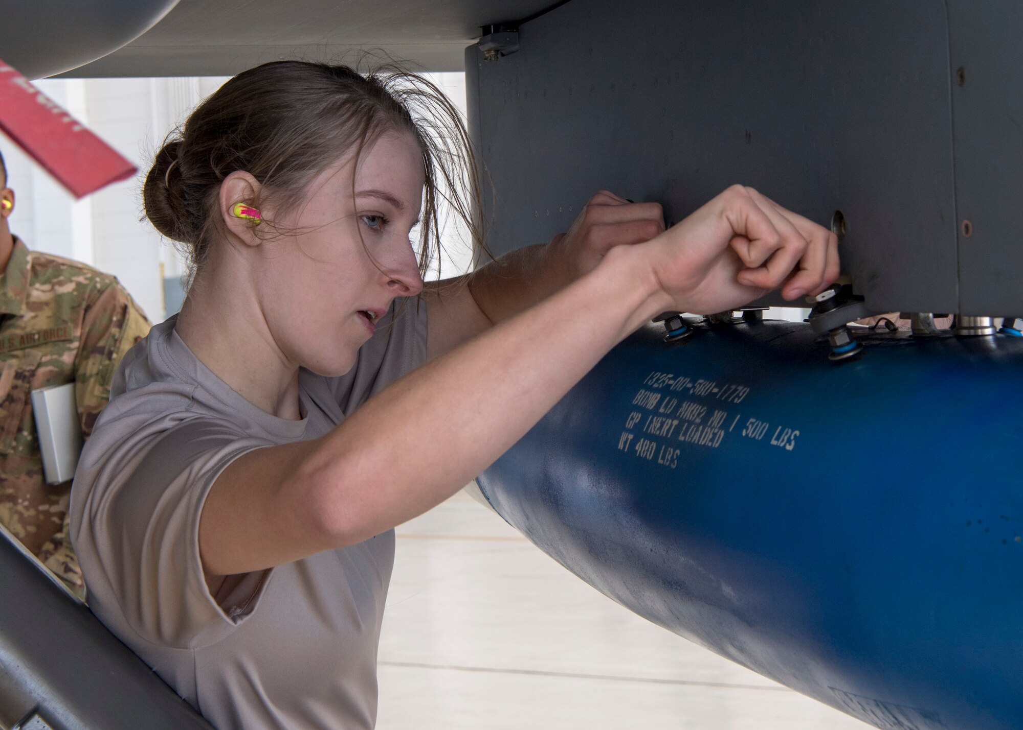 Senior Airman Ashley Falls, 29th Aircraft Maintenance Unit weapons load crew member, ensures the inert bomb on an MQ-9 Reaper is secure during a load competition, Oct. 28, 2019, on Holloman Air Force Base, N.M. Two F-16 Vipers and two MQ-9 Reapers were used to test the loading skills of 12 Airmen during the 2019 third quarter load competition. (U.S. Air Force photo by Airman 1st Class Autumn Vogt)