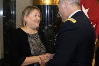 Gen. Gustave F. Perna, U.S. Army Materiel Command commanding general, presents a coin to Yvonne Bennett welcoming her to the AMC family shortly after her husband, Brig. Gen. Mark S. Bennett, took command of the U.S. Army Financial Management Command during a ceremony at the Indiana War Memorial in Indianapolis, Oct. 25, 2019. The change of command was the first formal event for USAMCOM since its move under AMC earlier in the month. (U.S. Army photo by Mark R. W. Orders-Woempner)