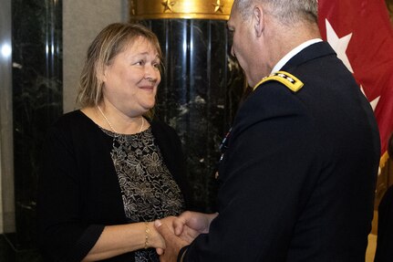 Gen. Gustave F. Perna, U.S. Army Materiel Command commanding general, presents a coin to Yvonne Bennett welcoming her to the AMC family shortly after her husband, Brig. Gen. Mark S. Bennett, took command of the U.S. Army Financial Management Command during a ceremony at the Indiana War Memorial in Indianapolis, Oct. 25, 2019. The change of command was the first formal event for USAMCOM since its move under AMC earlier in the month. (U.S. Army photo by Mark R. W. Orders-Woempner)