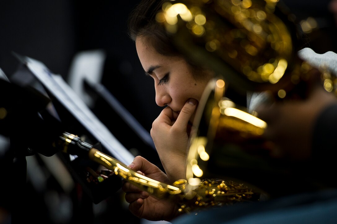 Close-up profile photo of a saxophonist’s face as she rests.