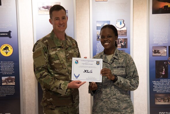 Capt. Kimera Joseph, a 47th Healthcare Operations Squadron pediatrician, accepts the “XLer of the week” award from Col. Todd Dyer, the 47th Flying Training Wing Vice Commander on Oct. 21, 2019 at Laughlin Air Force Base, Texas. The “XLer of the Week” award is given to those who consistently make outstanding contributions to their unit and the Laughlin mission. (U.S. Air Force photo by Staff Sgt. Benjamin Valmoja)