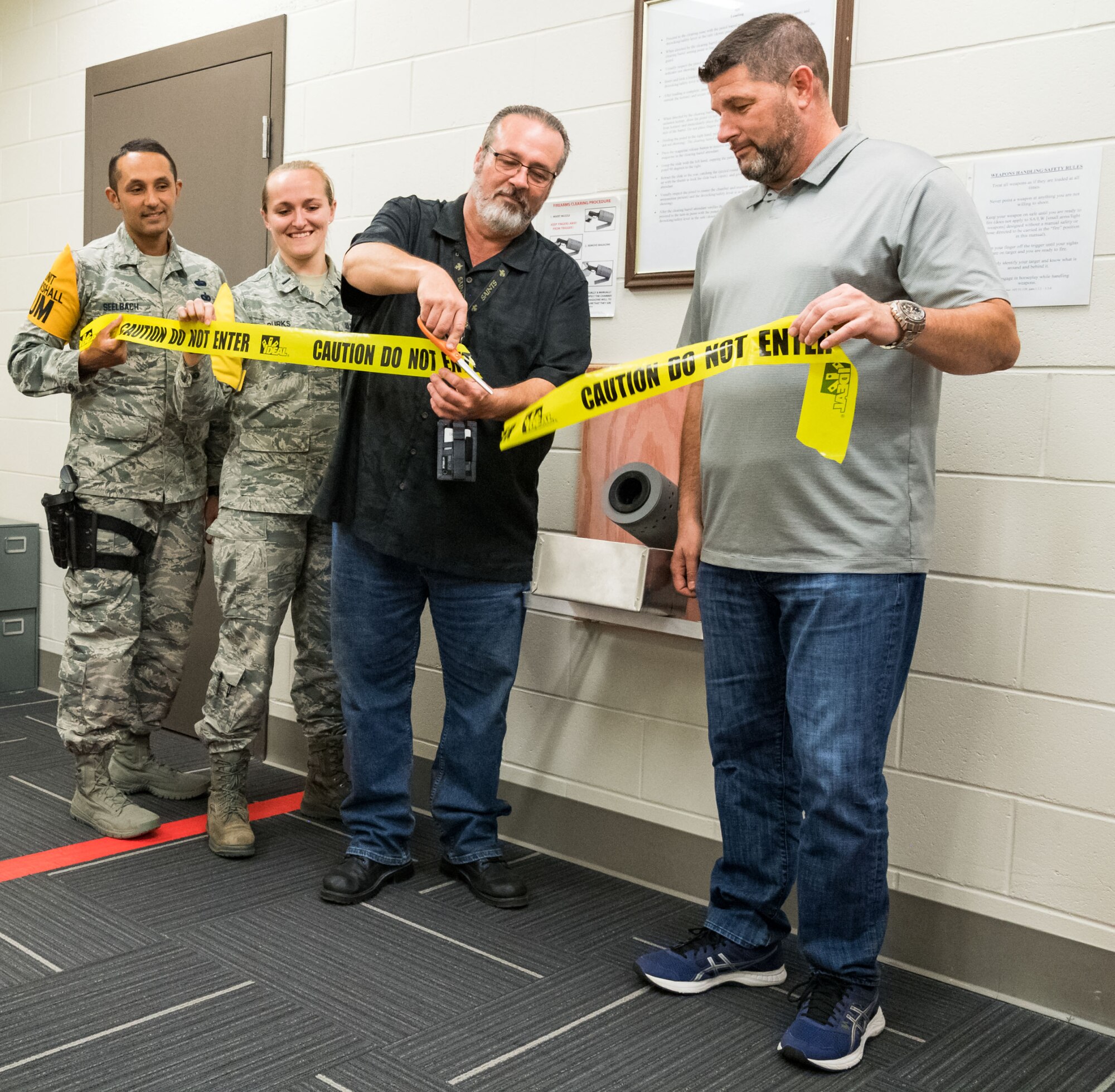 Tech. Sgt. Damien Seelbach, 436th Communications Squadron cybersecurity noncommissioned officer in charge and Unit Marshal; 1st Lt. Rachael Burks, 436 CS cyber operations flight commander and Unit Marshal; Dr. Craig Gilbert, 436 CS chief of knowledge management and Unit Marshal Program Manager; and Richard Barker, 436th Security Forces Squadron, participate in a ribbon-cutting ceremony in the 436 CS’s arming area, Oct. 24, 2019, on Dover Air Force Base, Del. The 436 CS is the first squadron in the Air Force to create its own arming area in support of the Unit Marshal Program. (U.S. Air Force photo by Roland Balik)