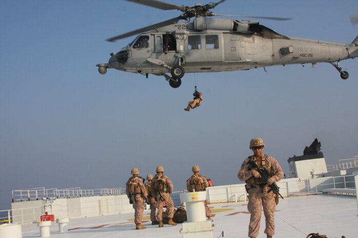 STRAIGHT OF HORMUZ (Oct 24, 2019) Marines assigned to Fleet Anti-Terrorism Security Team, Central Command (FASTCENT) prepare to be extracted by a Navy MH-60S Seahawk, attached to Helicopter Sea Combat Squadron 26 (HSC-26) from the Arc Liberty, a Military Sealift Command time chartered vessel, after providing security during a Strait of Hormuz transit. FASTCENT Marines work with U.S. partners and allies to protect personnel and property while simultaneously ensuring freedom of navigation in international waterways. Task Force 51 and 5th Marine Expeditionary Brigade is entrusted with rapidly aggregating crisis response capabilities and positioning Navy and Marine Corps forces throughout the U.S. Central Command area of responsibility to ensure command and control of forces at sea, from the sea, and ashore. (Photo by Marine Corps Cpl. Tanner A. Gerst)