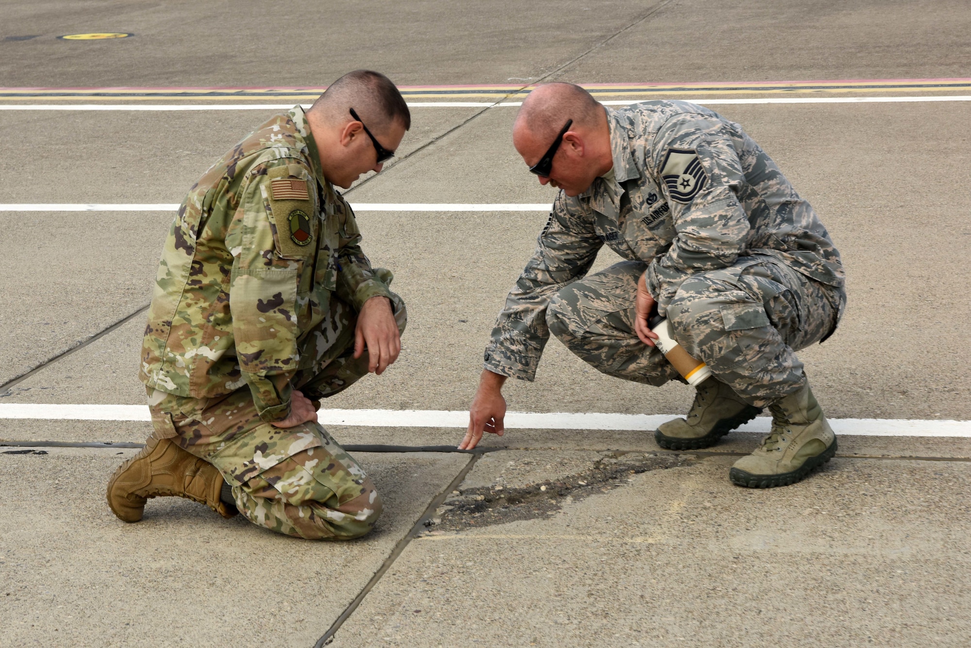 U.S. Air Force Tech. Sgt. Andrew Perna, 39th Civil Engineer Squadron pavement grounds contracting office representative, and Master Sgt. Gerald Bontrager, 39th CES first sergeant, inspect the airfield during Paver training Oct. 22, 2019, at Incirlik Air Base, Turkey. Paver is a software program that allows managers to prioritize airfield repairs to keep the airfield operational and keep costs low. (U.S. Air Force photo by Tech. Sgt. Jim Araos)