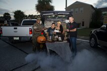 Col. William C. Gray, the 6th Marine Corps District commanding officer, and Sgt. Maj. William Banks III, 6MCD sergeant major, present an award to Gunnery Sgt. Tony J. Hernandez and family during a Trunk-or-Treat competition at 6MCD, MCRD Parris Island, South Carolina, Oct. 28, 2019. (U.S. Marine Corps photo by Sgt. Jorge A. Rosales)
