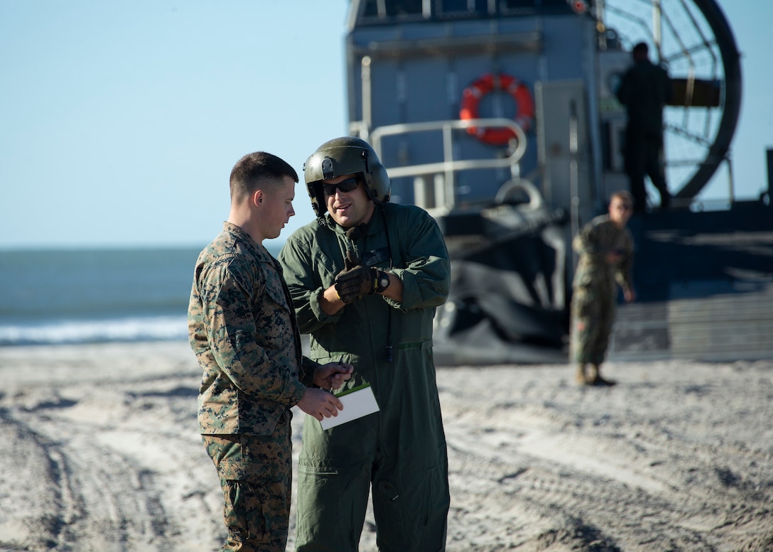 A U.S. Marine with 2nd Transportation Support Battalion, Combat Logistics Regiment 2, 2nd Marine Logistics Group, works with a Sailor from assigned to Assault Craft Unit 4, during Type Commander Amphibious Training 20.1 on Onslow Beach, Camp Lejeune, North Carolina, Oct. 21-26, 2019. TCAT is a mobility exercise ashore in order to gain the requisite skills and experience to integrate with the U.S. Navy in follow on exercises and real-world operations.