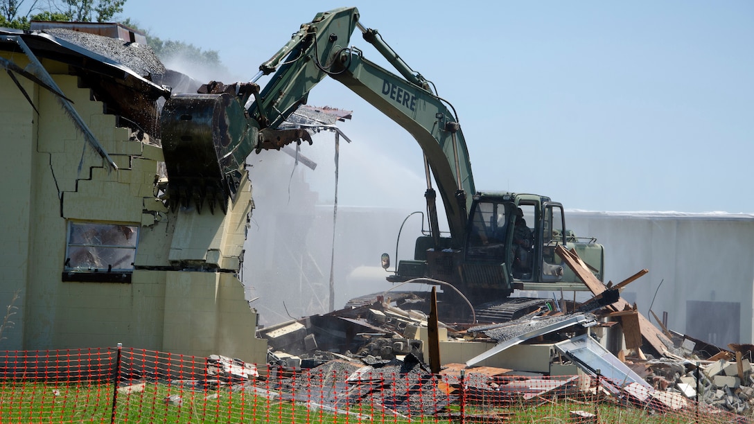 A Georgia Army National Guard Soldier operates an excavator to demolish a building