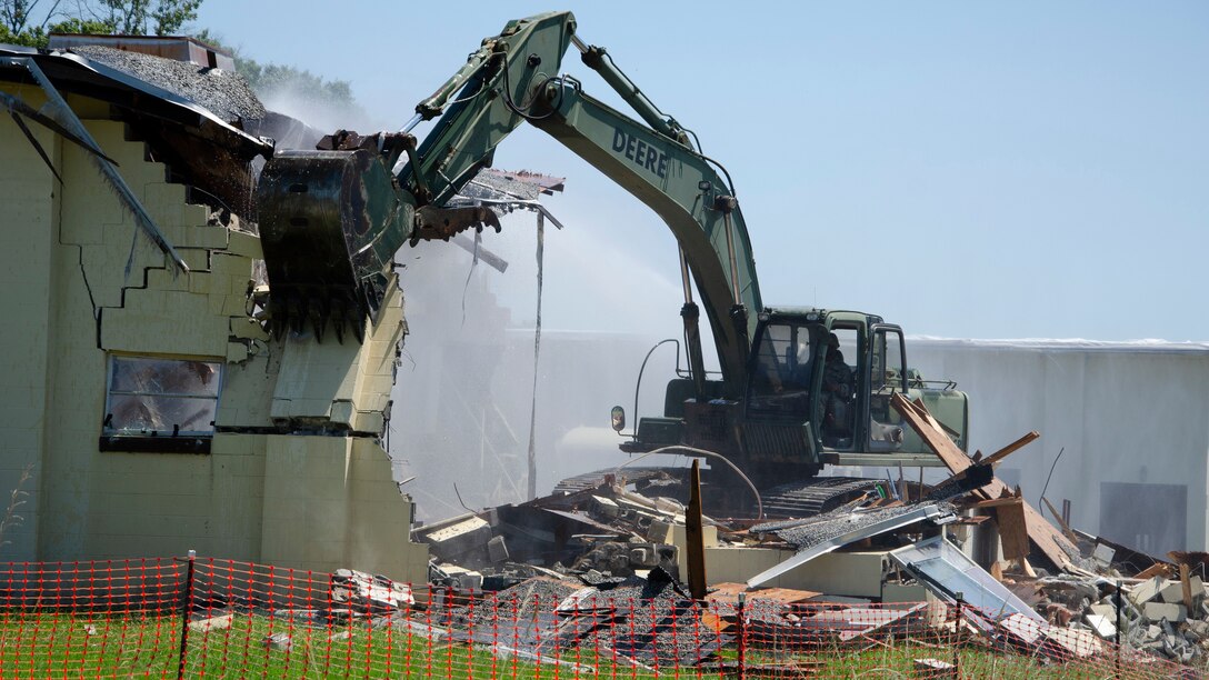 A Georgia Army National Guard Soldier operates an excavator to demolish a building