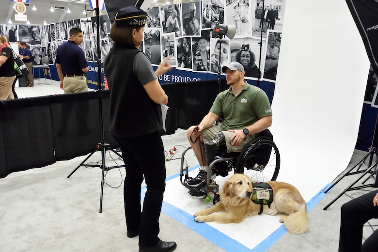 Stacy Pearsall speaking with veteran in wheelchair, photo session