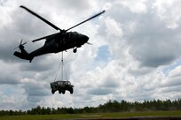 U.S. Army Soldiers with the 351st Aviation Support Battalion, South Carolina Army National Guard, hook up a Humvee to a UH-60 Black Hawk to practice sling load operations in the skies over Columbia, S.C., July 13, 2014.