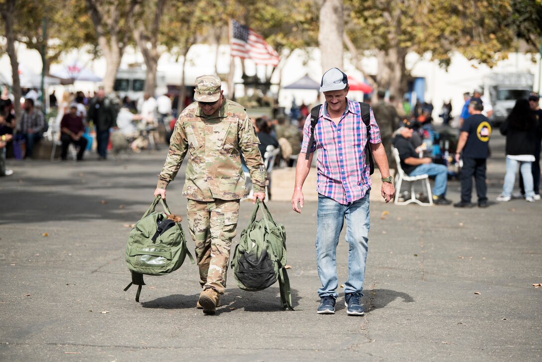 Master Sgt. Travis Martho, 30th Force Support Squadron Airman Leadership School commandant, carries supplies for a veteran during the 2019 Santa Barbara County Veteran Stand Down event Oct. 19, 2019, in Santa Maria, Calif. During the event, veterans were provided with clothes, shoes, a place shower, and other vital supplies and amenities. Veterans were also connected to more than 100 providers to aid them with services such as health care, legal help and vet care for their pets. (U.S. Air Force photo by Airman 1st Class Hanah Abercrombie)