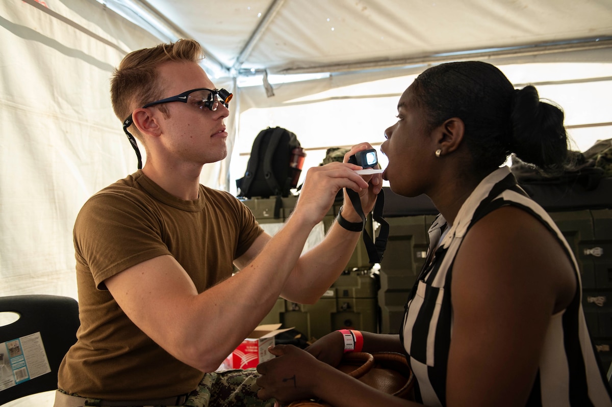 A dentist performs a dental exam on a woman.