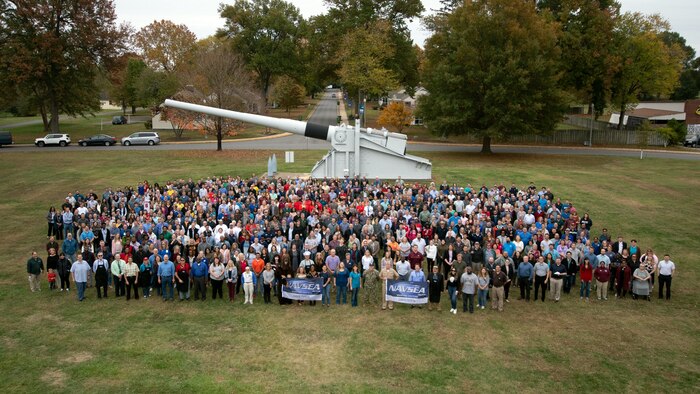 IMAGE: NSWC Dahlgren Division held a command picnic that featured lunch, music and sporting events at the parade field. Employees posed for a command photograph entitled "100 Years of NSWCDD Accomplishments" in front of the U.S. Navy 16-inch battleship gun.