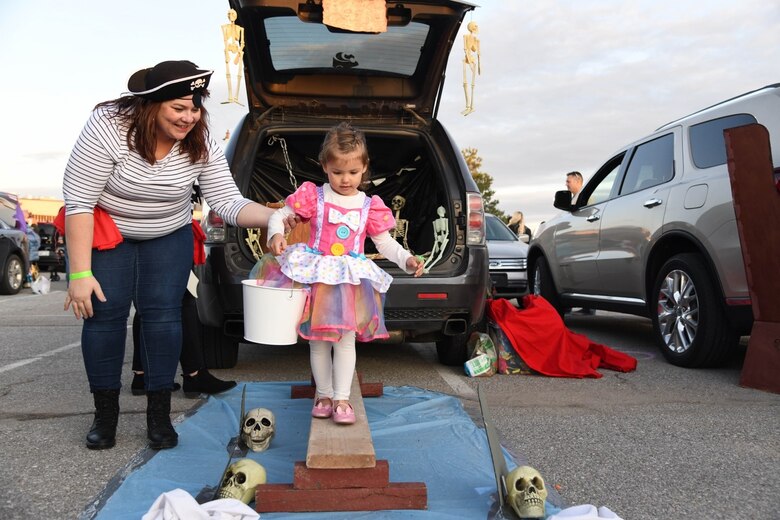 Avery Dimaio, age 2, walks the plank at the Trunk or Treat Spooktacular event Oct. 25, 2019 at McConnell Air Force base, Kan. Volunteers and squadrons from across the base displayed their Halloween themed cars as they passed out candy to children. At the end of the night, the five best trunks were awarded a $50 gift card. (U.S. Air Force photo by Airman 1st Class Nilsa E. Garcia)