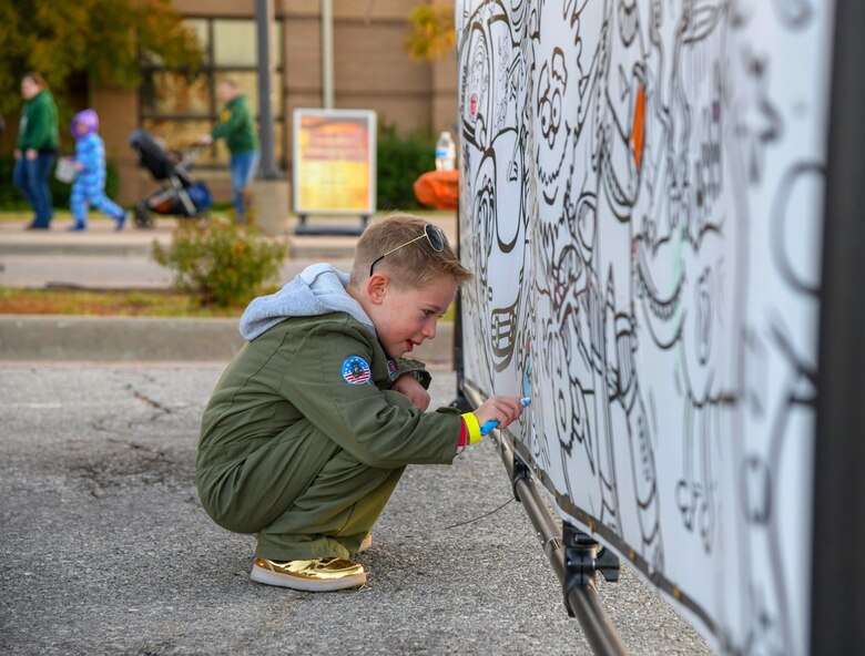 Alexander Price, age 7, colors on a community art wall at the Trunk or Treat Spooktacular event Oct. 25, 2019, at McConnell Air Force base, Kan. Price was one of over 1,800 individuals who attended the event. (U.S. Air Force photo by Airman 1st Class Nilsa E. Garcia)