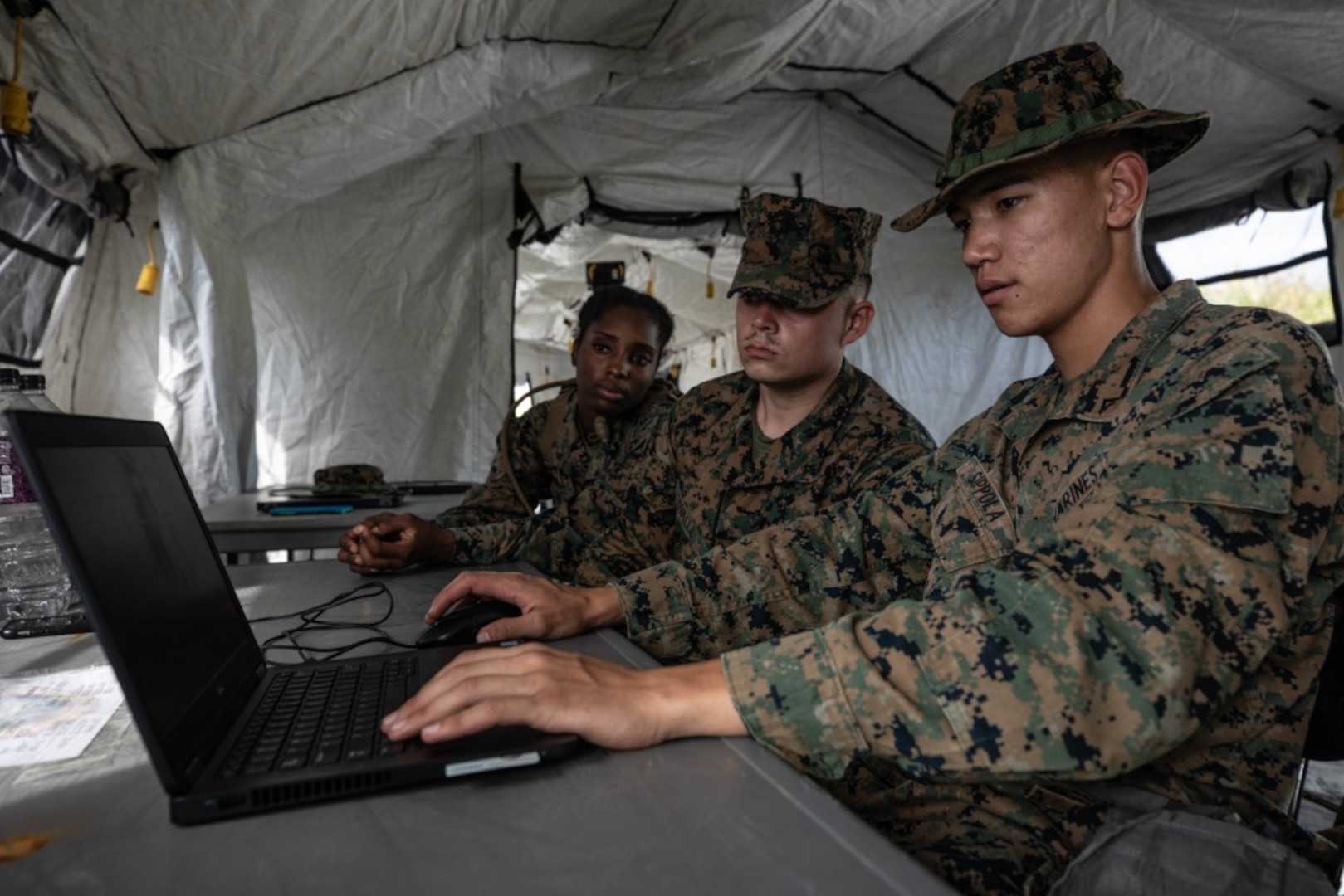 U.S. Marine Corps Lance Cpl. Kinyetta Alfred, left, Lance Cpl. Elijah Ovalle, center, and Lance Cpl. Serik Sippola prepare to ship gear during the 3rd Supply Battalion Marine Corps Combat Readiness Evaluation on Camp Hansen