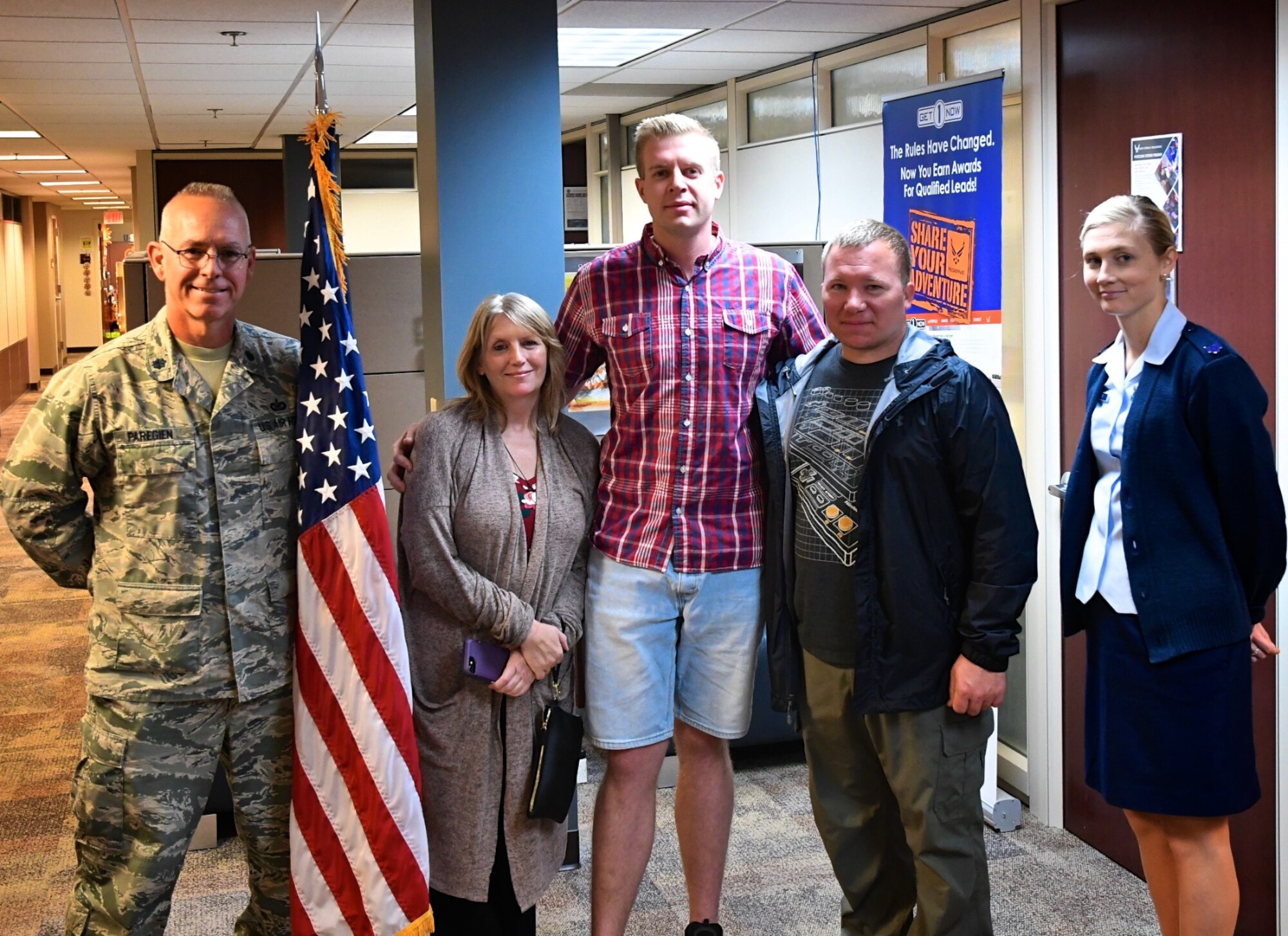 Welcome to the wing!  Maxwell Helgeson, at center, enlisted into the Air Force Reserve's explosive ordnance disposal field with the 932nd Airlift Wing on October 23, 2019, at Scott Air Force Base, Ill.  "I've been a Deputy Sheriff with Peoria County and wanted to do a special operations type job and do something special with the military.  My job as a deputy provides a background of dignity, discipline, hands on training with firearms, and public safety," said Helgesson.  His enlistment was performed by Lt. Col. Stan Paregien (at left) and paperwork and advice was provided by recruiter Staff Sgt. Jennifer Deimund, at right.  (U.S. Air Force photo by Master Sgt. David Pinkham)