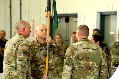 233rd Military Police Company 1st Sgt. Jeramie Mayes passes the company guidon during a change of responsibility during his retirement ceremony at Camp Lincoln, Springfield, Illinois. Mayes is retiring from the Illinois Army National Guard after a 31 year career.