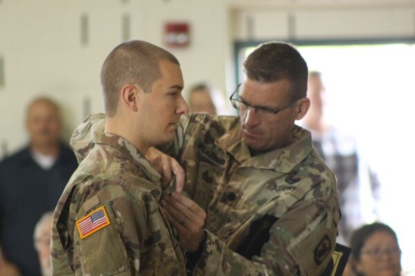 Lt. Col. Justin Wilkerson, of Peoria, Illinois, 404th  Manuever Enhancement Brigade, presents the Illinois National Guard Military Medal of Merit to 2nd Lt. Patrick J. Pendergast, of Plainfield, Illinois. Pendergast, who serves as a platoon leader in the 233rd Military Police Company based in Springfield, Illinois, was awarded the Military Medal of Merit for his contributions to the success of flood response operations during State Active Duty.