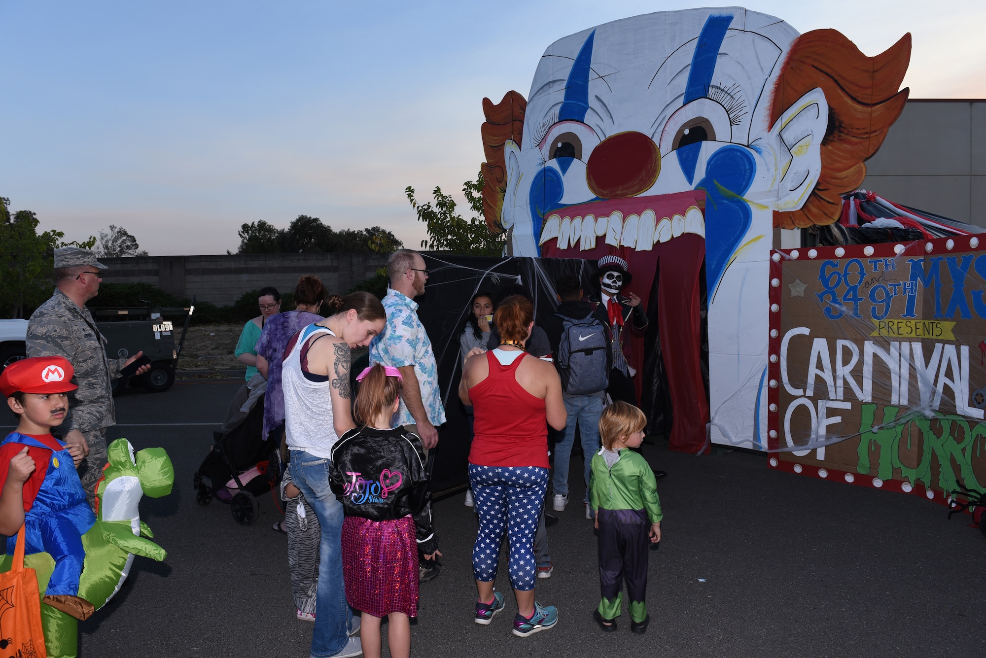 Travis Air Force Base families go through haunted houses at the Trunk-or-Treat event Oct. 25, 2019, at Travis AFB, California. The Airman and Family Readiness Center hosted Trunk-or-Treat, an annual event aimed to provide a safe place for military families to enjoy Halloween festivities. This was the first year Trunk-or-Treat had haunted houses set up, which were operated by the 60th Maintenance Squadron. The event had approximately 5,000 attendees and more than 60 vehicle trunks loaded with candy. (U.S. Air Force photo by Airman 1st Class Cameron Otte)
