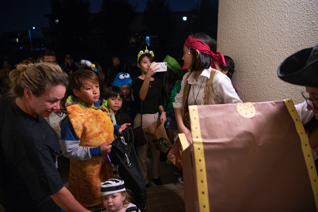 Children from Kadena Air Base, Japan, and Okinawa receive candy during a Halloween trick-or-treat event Oct. 31, 2019. The base opened its gates to the local community to share the traditional custom of trick-or-treating to enhance relations with host nation partners. (U.S. Air Force photo by Senior Airman Rhett Isbell)